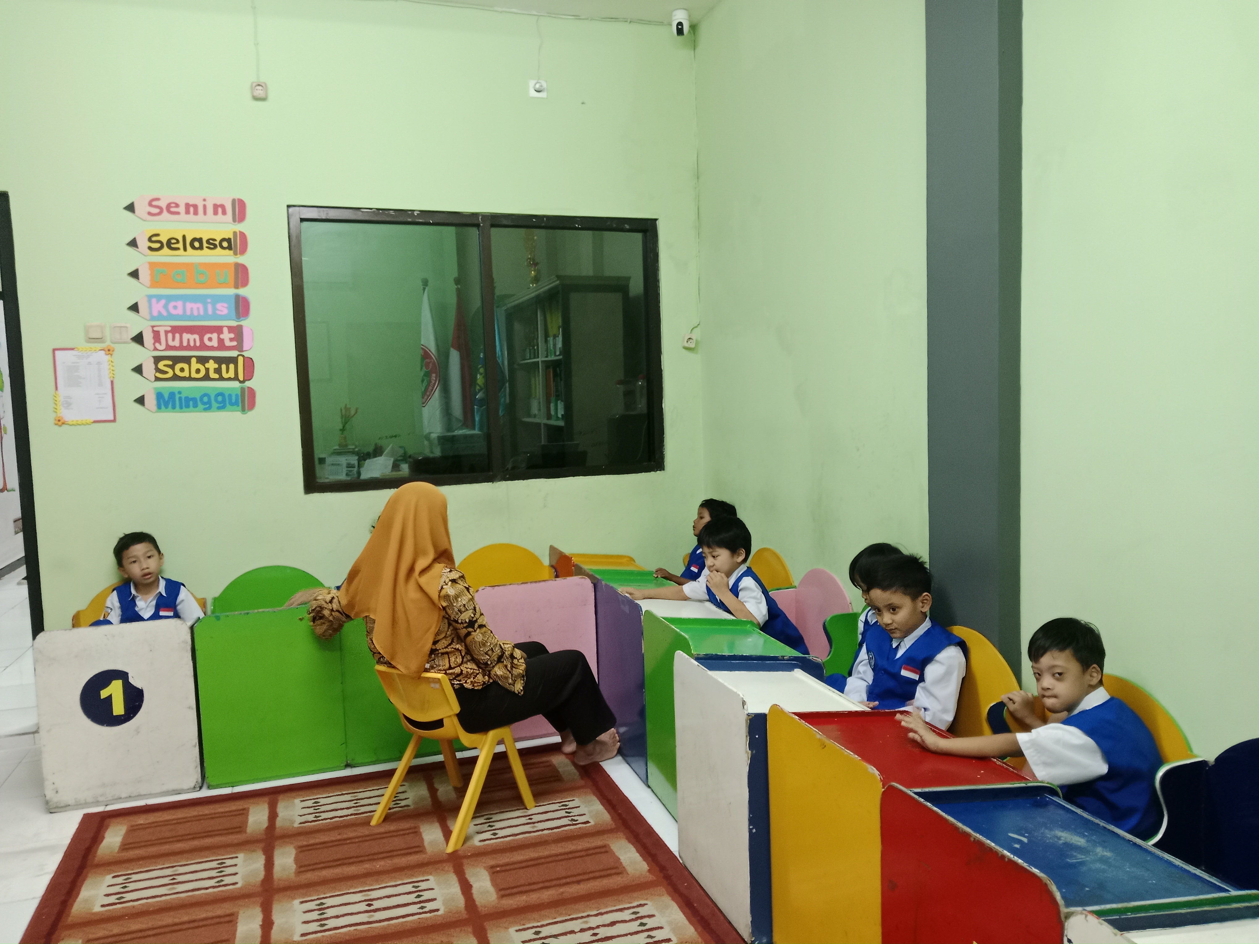<p>Menjaga anak2 di dalam kelas sambil bernyanyi m...