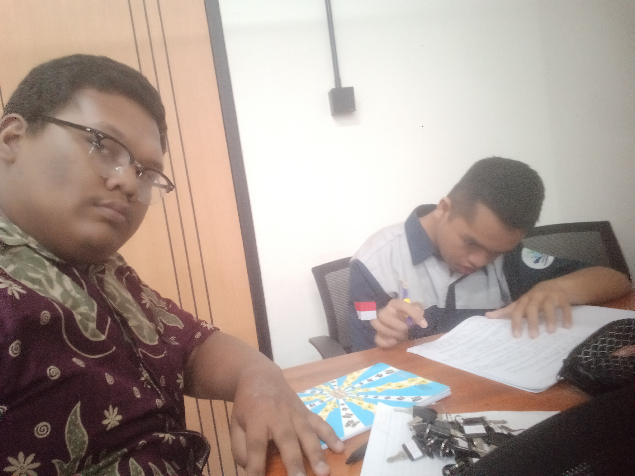 <p>Saya mendimpingi Riswan untuk mengerjakan buku...