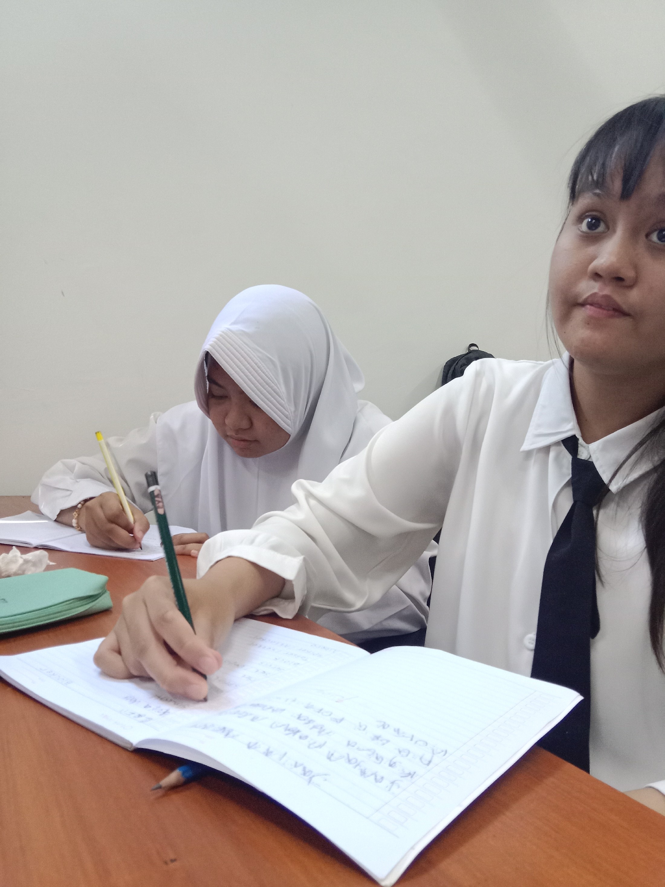 <p>Mendampingi Eva dan Tisya menulis materi pelaja...