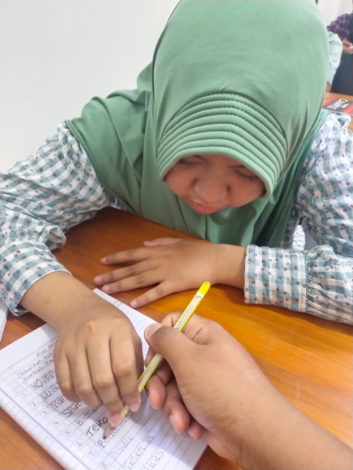 <p>Saya mendimpingi siswa tisya menebalkan tulisan...