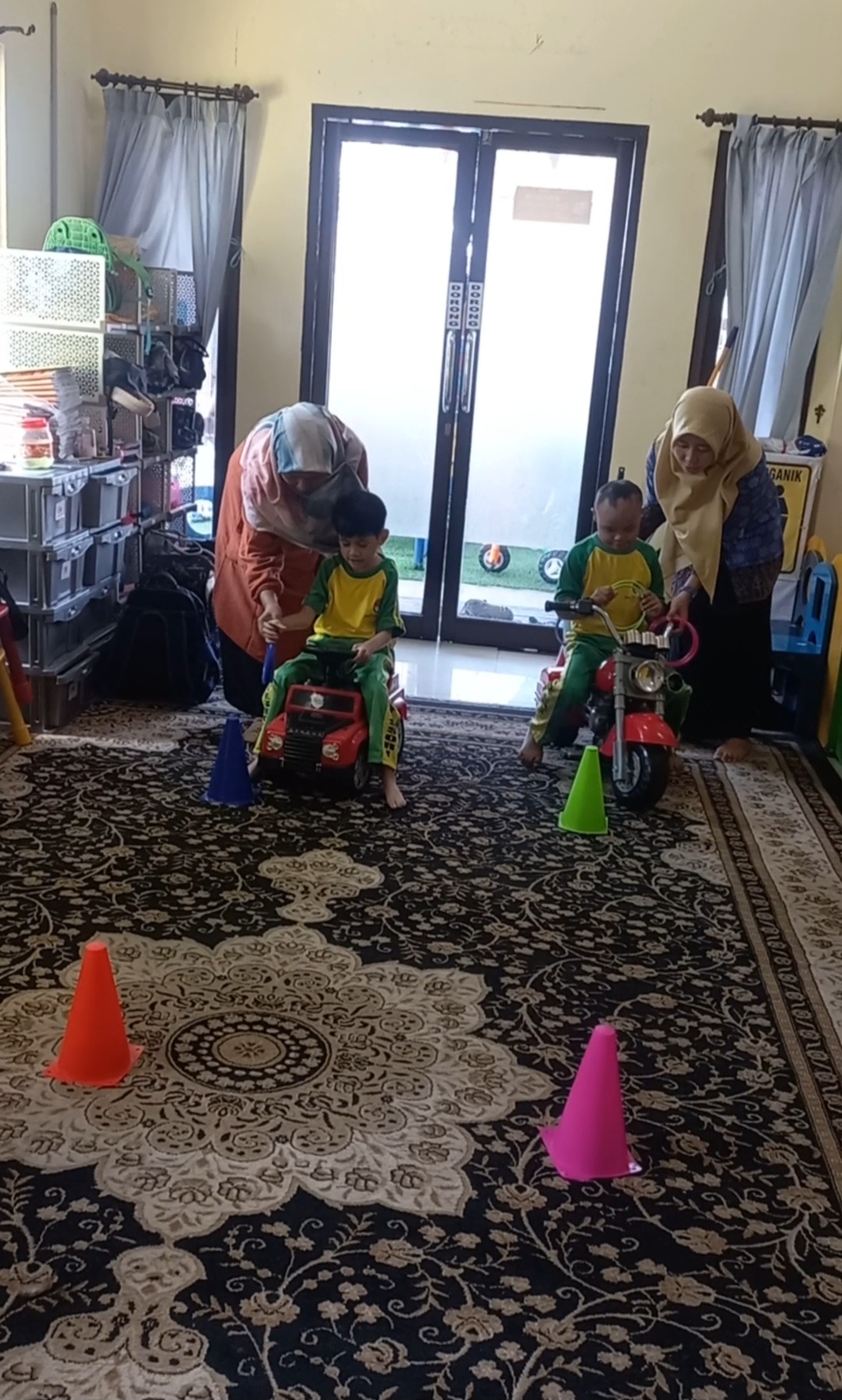 Naik sepeda tolo/scuter dan memasukkan gelang ke dalam cone sesuai warna