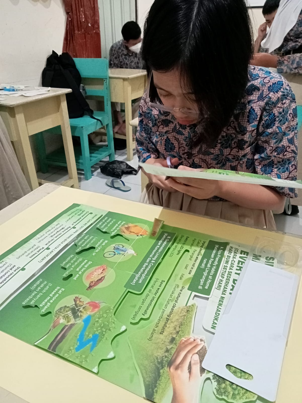 Mengerjakan Ujian praktik Bahasa Inggris, membuat poster bertema Science.